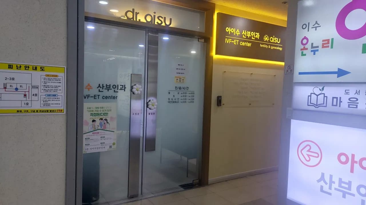 간접 조명 사인이 설치된 산부인과 유리 출입구와 진료시간 안내