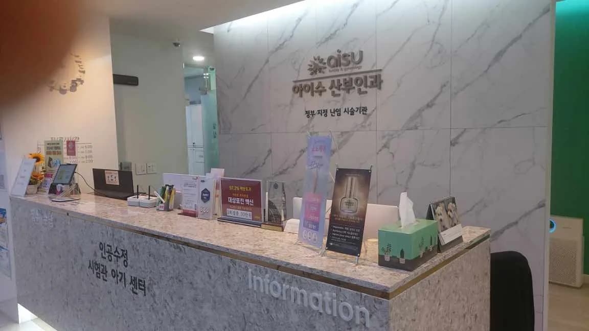 대리석 무늬 벽과 로고 사인이 있는 산부인과 접수 카운터