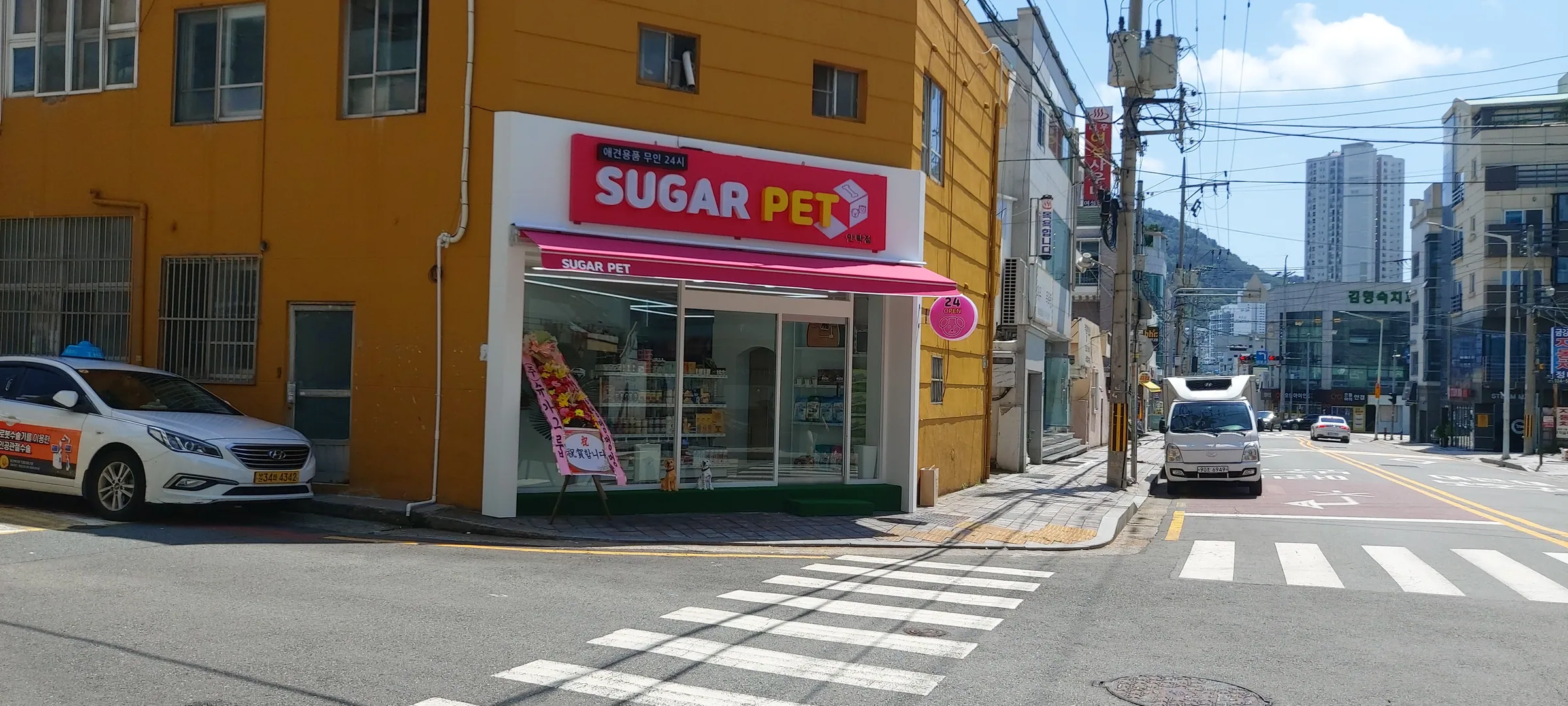 옥상 콘크리트 바닥에서 코팅재를 시공하는 작업자 세 명과 도료 드럼, 규사 포대