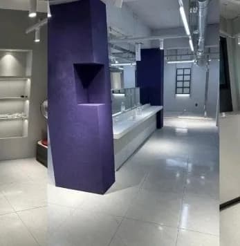 보라색 기둥 마감과 거울이 설치된 미용실 내부