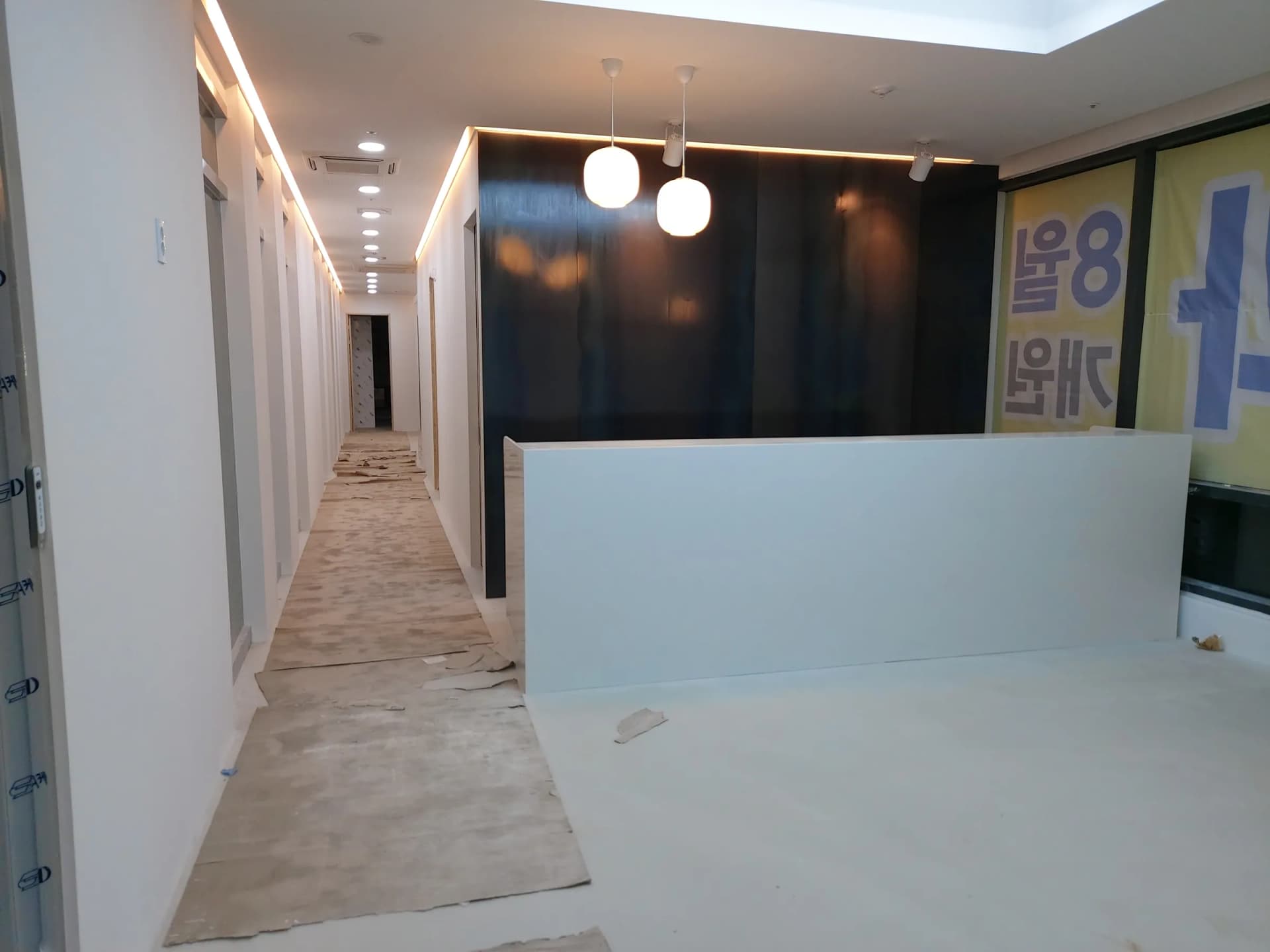바닥 양생지가 깔린 시공 중의 접수 카운터 구역